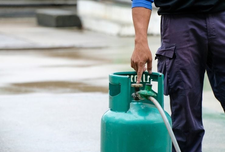 Ein Mitarbeiter prüft eine Gasflasche im Gefahrgutmanagement.