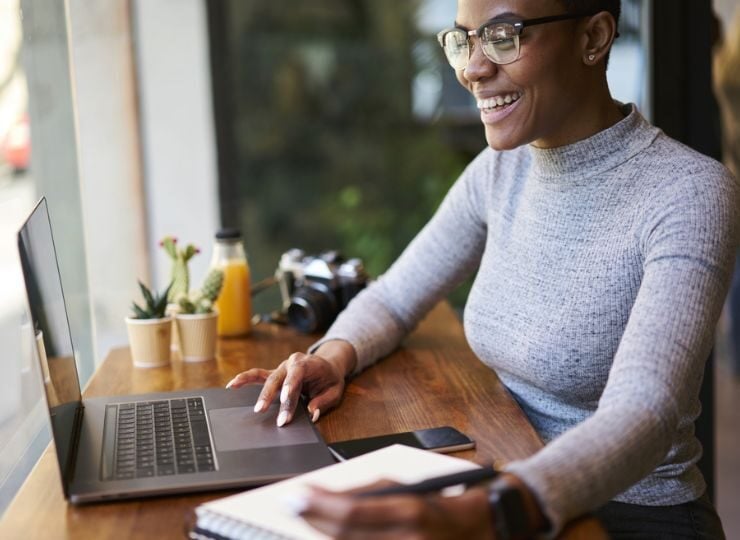 Eine Frau informiert sich vor einer Geschäftsreise am Laptop über Reisemedizin.