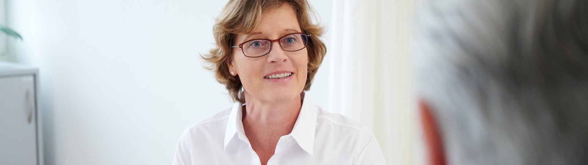 Eine Betriebsärztin berät einen Mitarbeiter im Unternehmen.