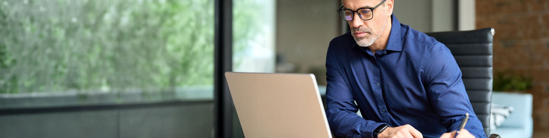 Ein Mann bucht arbeitsmedizinische Leistungen über den Laptop.