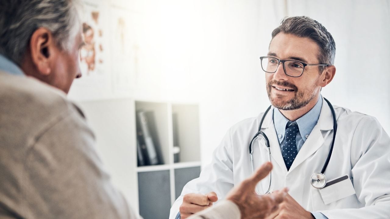 Ein Betriebsarzt berät einen Mitarbeitenden zur Arbeitsmedizin.