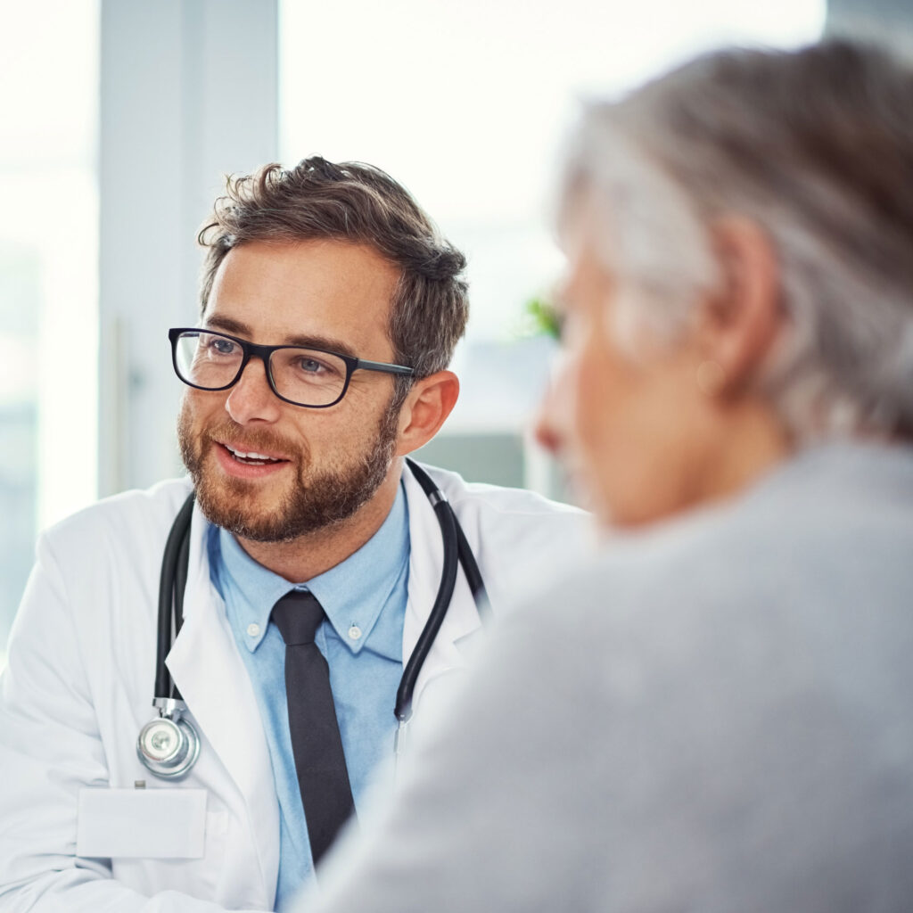 Ein Betriebsarzt berät einen Mitarbeiter zur Arbeitsmedizin.